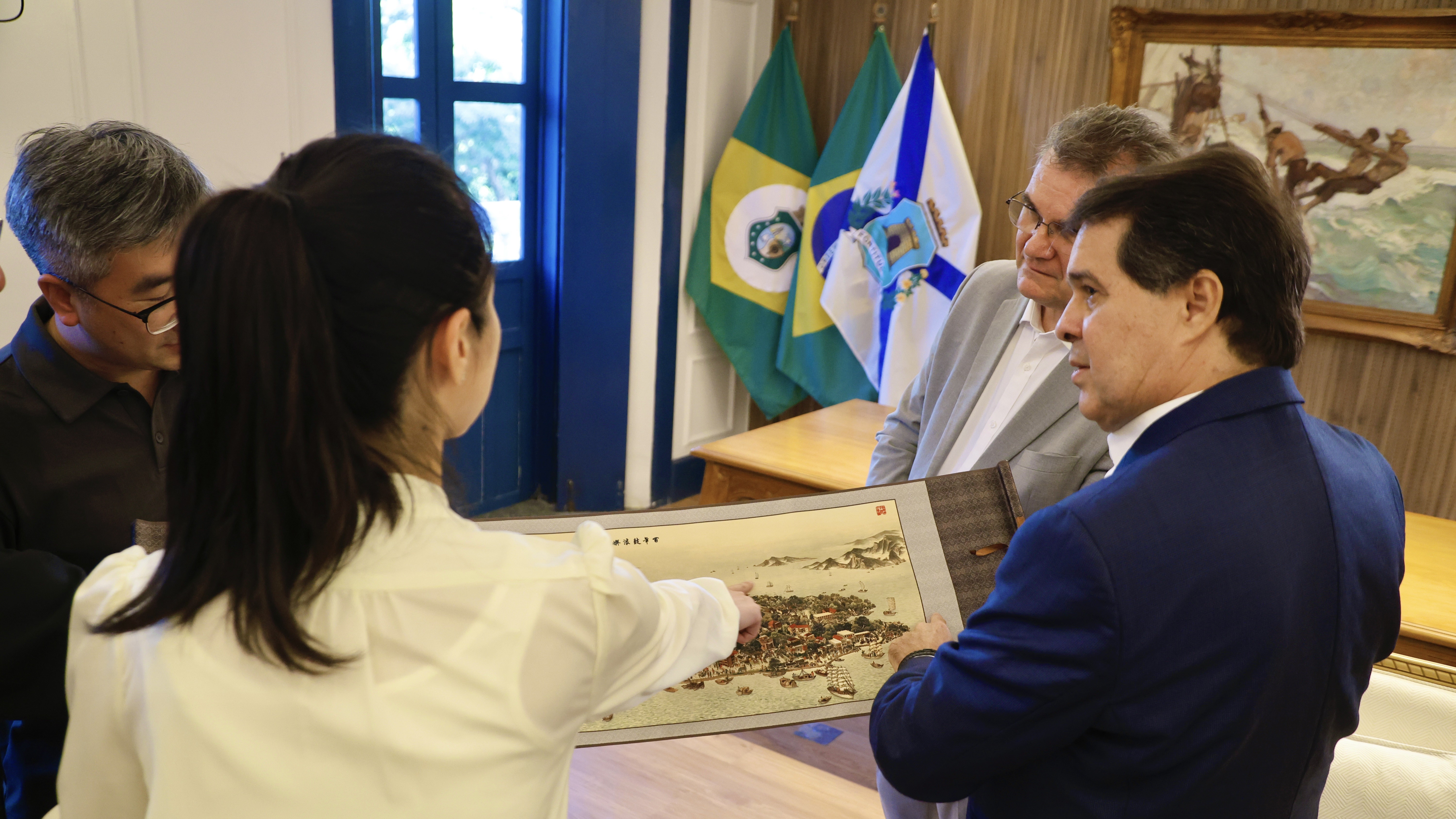 prefeito evandro olha um mapa da cidade de Xiamen em seu gabinete; ele está acompanhado de pessoas da equipe do documentário chinês